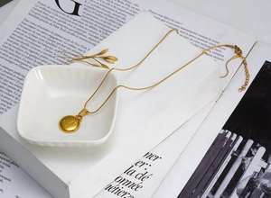 Detailed macro of 18K gold plated Scorpio zodiac coin pendant on a sleek snake chain