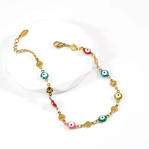 Detail of 18K gold-plated evil eye bracelet with colorful beads and heart pendants