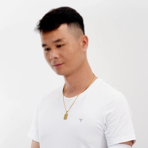 Détail d'un collier rectangulaire en titane plaqué or avec pendentif lettre A sur un homme