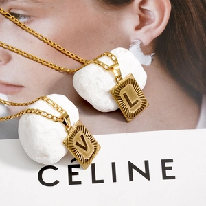 Collier Figaro en acier titane doré avec pendentif carré lettre L et V sur pierre blanche