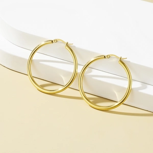 Minimalist gold stainless steel hoop earrings with polished finish on geometric stand