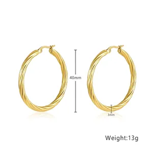 Detail of 40mm golden twist hoop earrings featuring spiral texture and latch back closure
