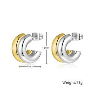 Macro detail of 13mm two-tone stainless steel C-shape chunky hoop earrings in gold and silver