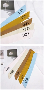 Detail of multi-color satin twilly scarves with LCC letter print on white fabric