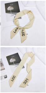 Detail of cream silk scarf with black LCC letter print used as a knotted headband