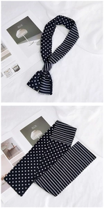 Détail d'un foulard en soie noir et blanc avec motifs à pois et rayures croisées