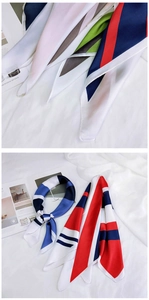 Détail d'un foulard carré en soie avec des motifs géométriques à rayures bleues et rouges
