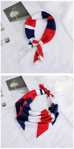Détail d'un foulard en soie à rayures géométriques rouge blanc bleu avec fini satiné