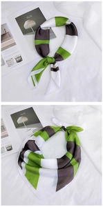 Détail d'un foulard en soie tricolore noué avec des motifs géométriques vert et marron