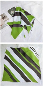 Détail d'un foulard carré en soie à rayures vertes, noires et blanches avec bords roulés