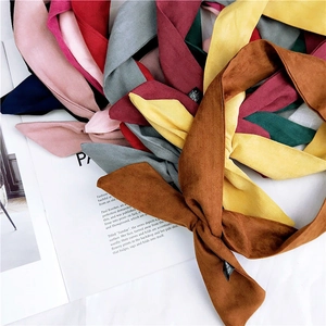Foulards fins en suédine de diverses couleurs posés sur un magazine de mode