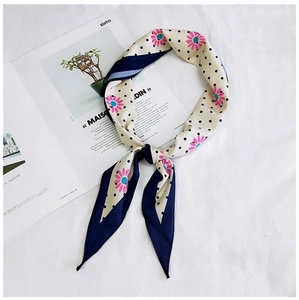 Detailed shot of a floral polka dot neck scarf on a minimalist fashion magazine background