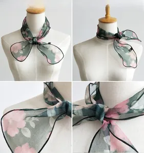 Macro view of organza neck scarf with floral print and delicate black hemmed edges