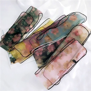 Lightweight floral organza scarves displayed on fabric background as stylish hair ribbons