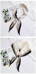 Close-up of beige diamond silk scarf with black border and elegant script lettering