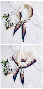 Detail of silk-feel rhombic scarf with geometric borders and elegant script prints