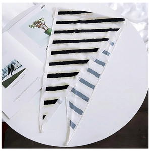Close-up of a striped silk scarf with gray and black patterns on a white table