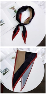 Detail of a geometric color-block silk scarf showing the elegant drape and care label