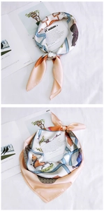 Detail view of pink equestrian silk scarf featuring horse patterns and magazine styling