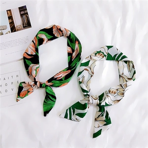 Tropical leaf print skinny silk scarves in black and white tied as elegant bows