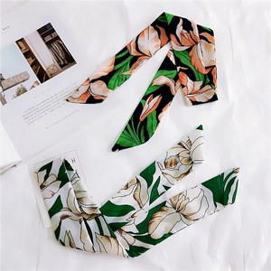 Flat lay of floral satin twilly scarves on white paper for hair or bag handles