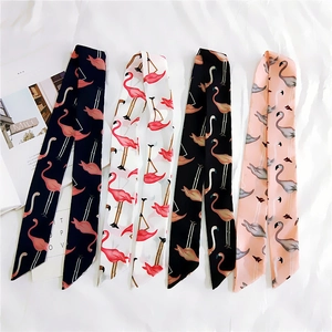 Flat lay of four chiffon twilly scarves with elegant flamingo prints in various colors