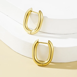 Boucles d'oreilles créoles en U plaquées or 18K sur des supports géométriques blancs