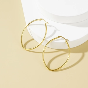 Minimalist Mobius stainless steel gold hoop earrings on a white elegant pedestal