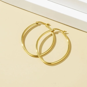 Minimalist Mobius stainless steel gold hoop earrings displayed on geometric prop