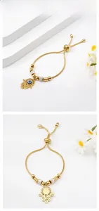 Close-up of golden Hamsa Hand bracelet with Evil Eye charm and snake chain detail