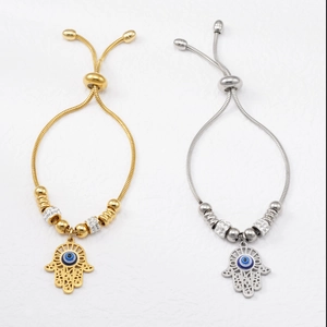 Close-up of Evil Eye Hamsa Hand pendants on adjustable snake chains in gold and silver