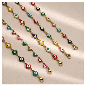 Macro detail of Turkish evil eye and Hamsa hand gold bracelets with colorful enamel
