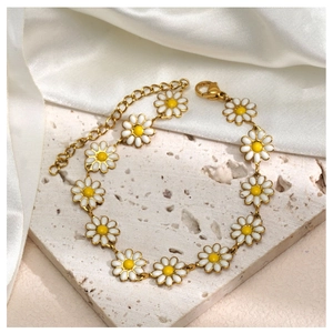 Détail d'un bracelet marguerite doré avec pétales en émail et fermoir mousqueton