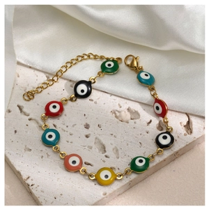 Macro detail of colorful enamel evil eye beads on adjustable gold plated bracelet