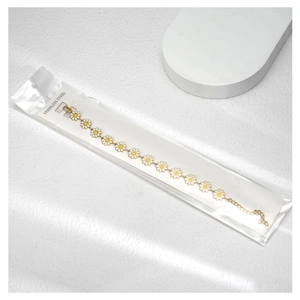 Détail du bracelet marguerite avec pétales en émail blanc sur une chaîne en acier doré