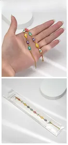 Détails macro des charmes œil porte-bonheur émaillés sur un bracelet en acier doré