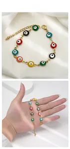 Detailed view of colorful enamel evil eye bracelet with golden lobster clasp and chain