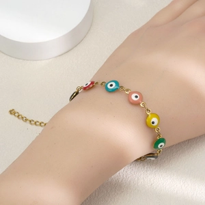 Gold Evil Eye bracelet with colorful enamel charms shown on model wrist for women