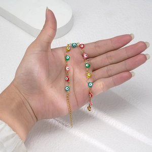 Bracelet cœur coloré avec œil grec et chaîne dorée porté pour la chance