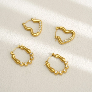 Gros plan sur les boucles d'oreilles cœur et ovales en or 18k ornées de zircones blancs