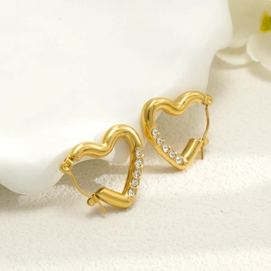 Détail de boucles d'oreilles cœur 18k avec zircons blancs sur un support d'exposition