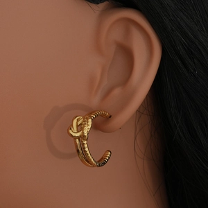 Orecchini a cerchio a C in oro 18K con design a nodo intrecciato indossati dal modello