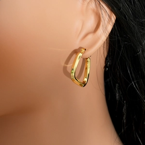 Close-up of gold irregular geometric hoop earrings on a model showing the polished finish