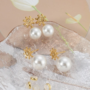 Macro detail of 18k gold-plated helm pearl earrings with crystal center and soft ear backs