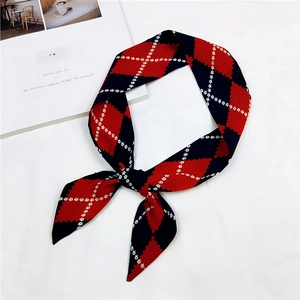 Detailed view of a red and black diamond pattern narrow scarf tied in a stylish knot