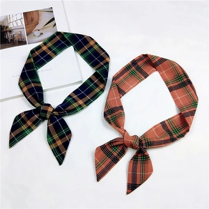 Detail of plaid bow hair scarves in navy blue and pink checkered patterns for handbags