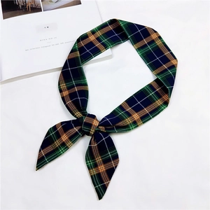 Detailed close-up of a classic plaid skinny silk scarf knotted on a white background