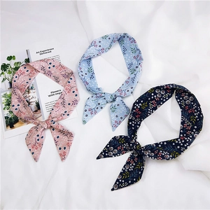 Detailed view of floral silk scarves in pink and blue for hair or bag handles decor