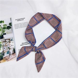 Detail of red and blue checkered silk ribbon tied in a bow on a white fabric background