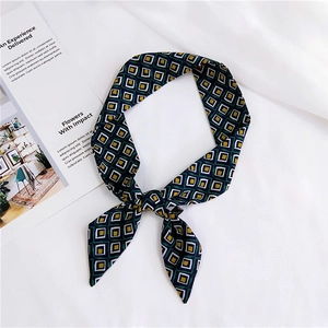 Detail of a retro geometric pattern silk scarf used as a bag strap or hair tie